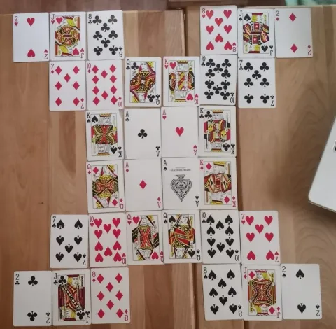 A set of playing of cards laid out in a grid with the aces in the center